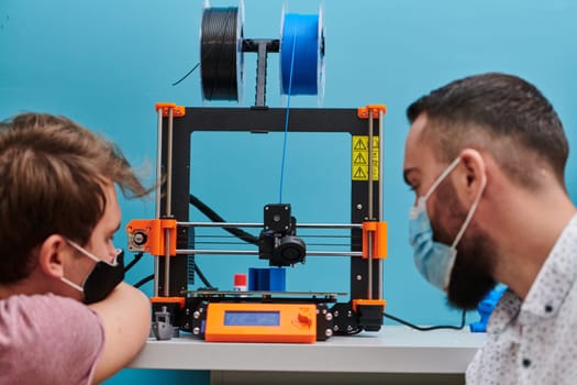 A group of colleagues collaborate in a lab while testing a 3D printer, demonstrating their commitment to technological advancement and scientific research