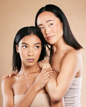 Beauty, skincare and diversity women friends in studio for dermatology, makeup and cosmetics. Asian and black person together for skin glow, wellness spa facial and love of inclusion for foundation.