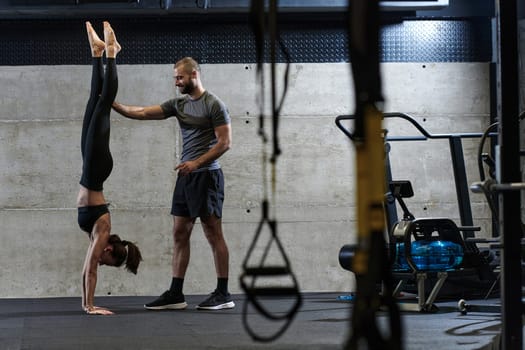 A muscular man assisting a fit woman in a modern gym as they engage in various body exercises and muscle stretches, showcasing their dedication to fitness and benefiting from teamwork and support.