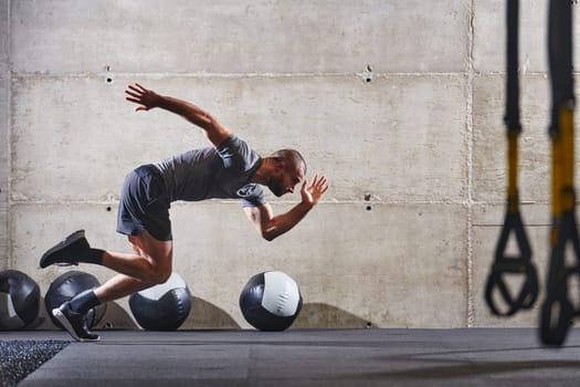 A muscular man captured in air as he jumps in a modern gym, showcasing his athleticism, power, and determination through a highintensity fitness routine.