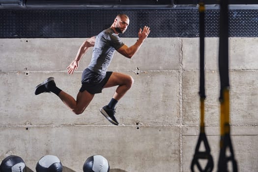 A muscular man captured in air as he jumps in a modern gym, showcasing his athleticism, power, and determination through a highintensity fitness routine.