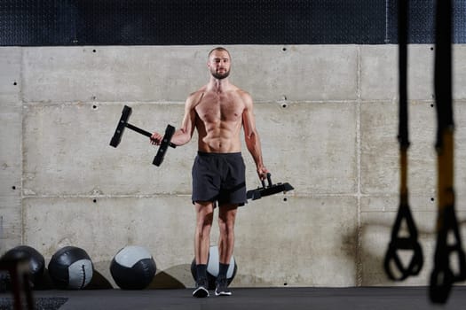 A muscular man performs shoulder exercises in a modern gym, showcasing his strength and dedication to fitness