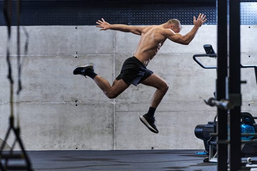 A muscular man captured in air as he jumps in a modern gym, showcasing his athleticism, power, and determination through a highintensity fitness routine.