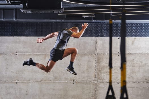 A muscular man captured in air as he jumps in a modern gym, showcasing his athleticism, power, and determination through a highintensity fitness routine.