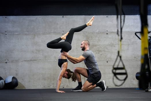 A muscular man assisting a fit woman in a modern gym as they engage in various body exercises and muscle stretches, showcasing their dedication to fitness and benefiting from teamwork and support.