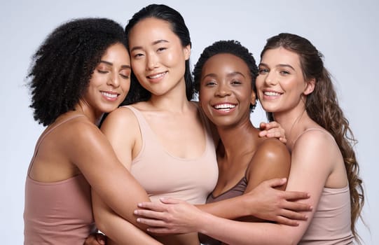 Skincare, support and diversity of women with a hug for makeup collaboration, cosmetics and beauty on a studio background. Affection, happy and portrait of model friends with cosmetic empowerment.