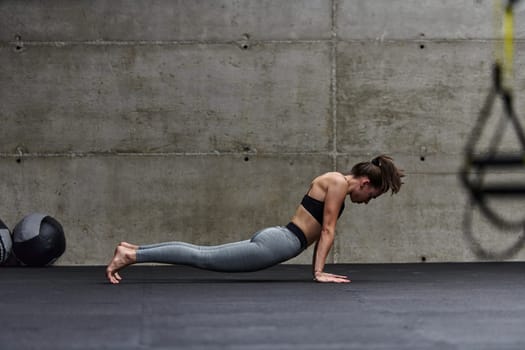 Fit woman in a modern gym working flexibility and strength through various exercises, demonstrating her commitment to fitness.