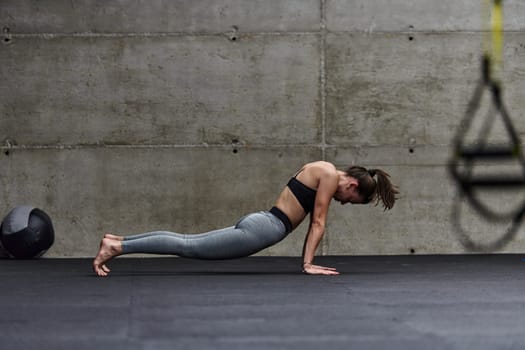 Fit woman in a modern gym working flexibility and strength through various exercises, demonstrating her commitment to fitness.