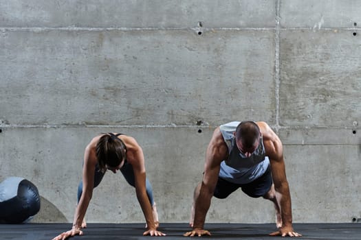 An attractive couple in the gym engaging in various stretching exercises together, showcasing their dedication to fitness, flexibility, and overall wellbeing. With synchronized movements, they demonstrate coordination, balance, and endurance while supporting and motivating each other on their fitness journey.