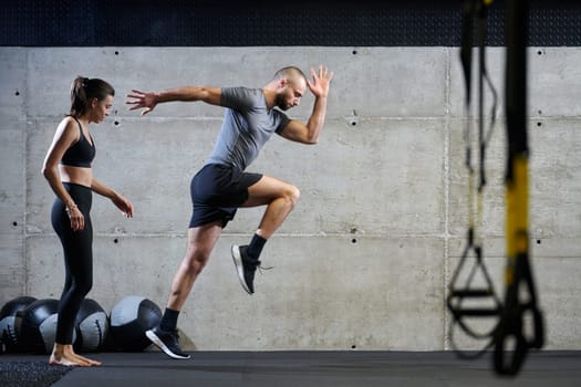 A fit couple in a modern gym, engaging in running exercises and showcasing their athletic prowess with a dynamic start