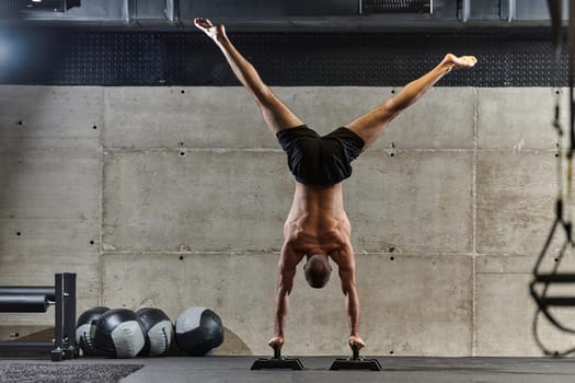 A muscular man in a handstand position, showcasing his exceptional balance and body control while performing a variety of exercises to enhance his overall body stability and strength in a modern gym.
