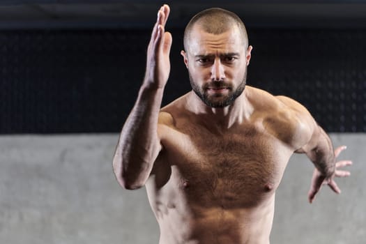 A muscular man standing in the starting position for running, exuding determination and readiness for an intense fitness workout or athletic competition