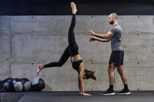 A muscular man assisting a fit woman in a modern gym as they engage in various body exercises and muscle stretches, showcasing their dedication to fitness and benefiting from teamwork and support.