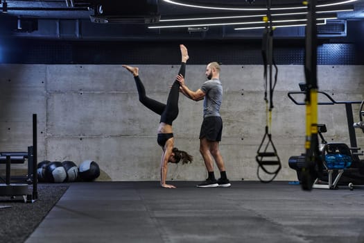 A muscular man assisting a fit woman in a modern gym as they engage in various body exercises and muscle stretches, showcasing their dedication to fitness and benefiting from teamwork and support.