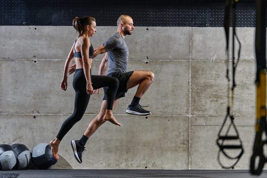 A fit couple exercising various types of jumps in a modern gym, demonstrating their physical fitness, strength, and athletic performance.