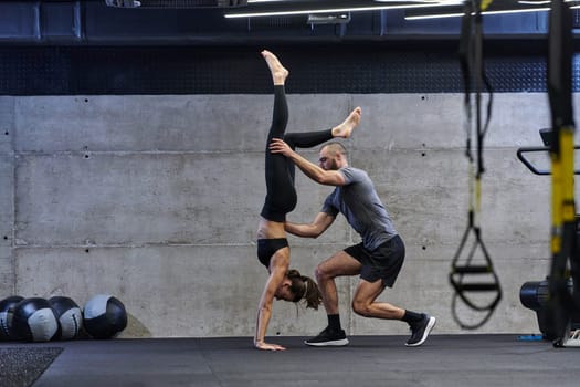 A muscular man assisting a fit woman in a modern gym as they engage in various body exercises and muscle stretches, showcasing their dedication to fitness and benefiting from teamwork and support.