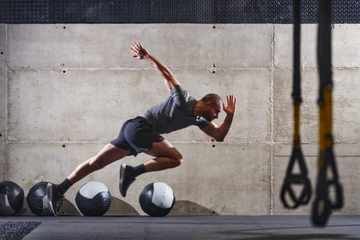 A muscular man captured in air as he jumps in a modern gym, showcasing his athleticism, power, and determination through a highintensity fitness routine.