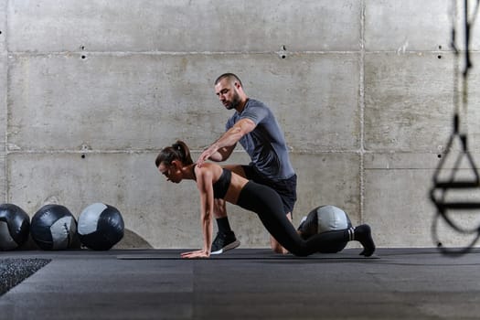 A muscular man assisting a fit woman in a modern gym as they engage in various body exercises and muscle stretches, showcasing their dedication to fitness and benefiting from teamwork and support.