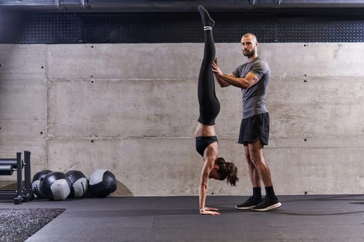 A muscular man assisting a fit woman in a modern gym as they engage in various body exercises and muscle stretches, showcasing their dedication to fitness and benefiting from teamwork and support.