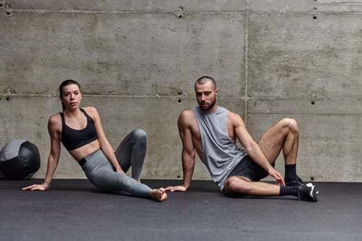 An attractive couple in the gym engaging in various stretching exercises together, showcasing their dedication to fitness, flexibility, and overall wellbeing. With synchronized movements, they demonstrate coordination, balance, and endurance while supporting and motivating each other on their fitness journey.