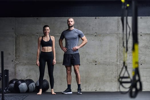 Muscular man and fit woman in a conversation before commencing their training session in a modern gym