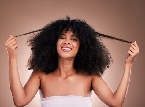 Hair in hands, beauty and portrait of black woman on brown background for wellness, shine and natural glow. Salon, luxury treatment and happy girl face with curly hairstyle, texture and afro growth.