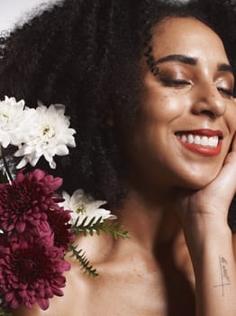 Wellness, flowers and beauty aesthetic model with skincare satisfaction and glowing texture routine. Aesthetic, health and makeup of black woman cosmetics model with beautiful smile in white studio.