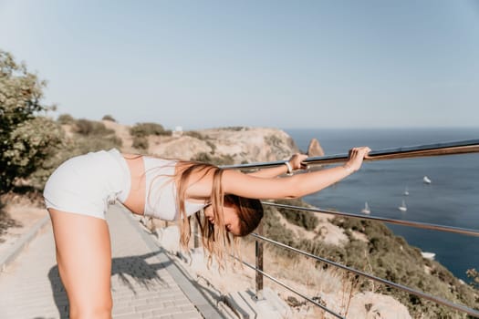 Fitness woman sea. Outdoor workout on yoga mat in park near to ocean beach. Female fitness pilates yoga routine concept. Healthy lifestyle. Happy fit woman exercising with rubber band in park.