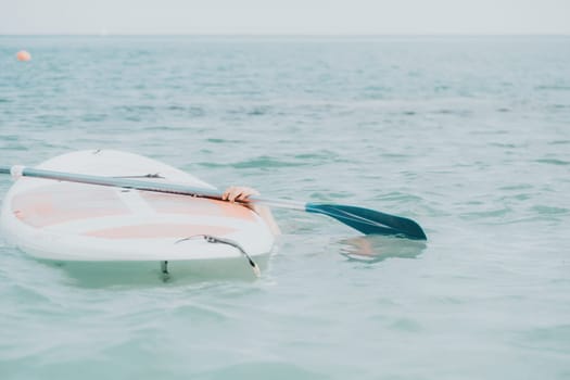 Sea woman sup. Silhouette of happy young woman in pink bikini, surfing on SUP board, confident paddling through water surface. Idyllic sunset. Active lifestyle at sea or river. Slow motion