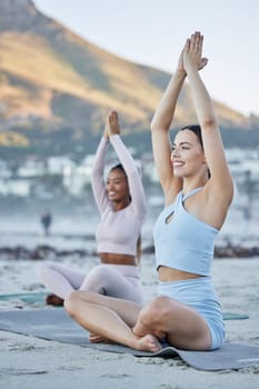 Woman, friends and yoga in meditation on the beach for healthy spiritual wellness, fitness or workout in the outdoors. Happy women relax in warm up stretch, meditating or zen exercise in Cape Town.