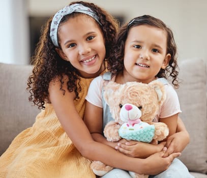 Family, children hug and portrait of girls on sofa in living room while holding teddy bear. Love, care and happy kids, sisters and siblings bonding, embrace and hugging on couch in lounge of house