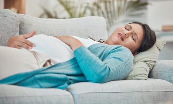 Pregnancy, cramps and woman with stomach pain on sofa holding abdomen in pain, discomfort and physical strain. Healthcare, baby and pregnant woman rest on couch suffering from maternity contractions.