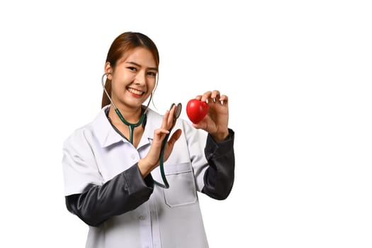 Smiling female doctor holding stethoscope and red heart isolated white background. Cardiology, medicine and healthcare concept.
