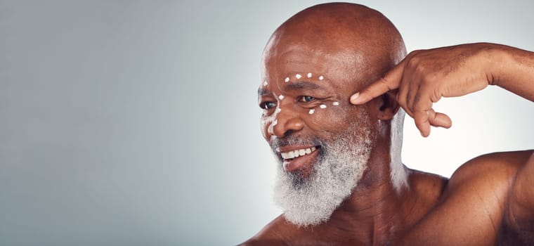 Skincare, face cream and senior man in studio for wellness, beauty and grooming against grey background. Facial, skin and elderly model relax with luxury, cosmetics and wrinkle product while isolated.