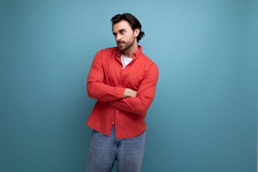 pensive young brunette man in red shirt.