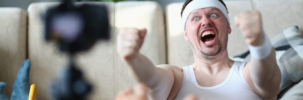 Motivated stubborn emotional man doing sports exercises in front of camera. Complexity of home fitness training and goal of losing weight