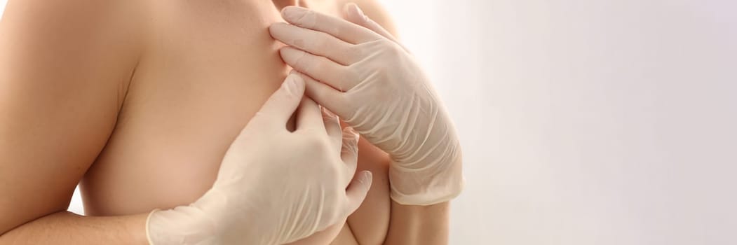 Breast cancer and healthcare. Young woman with slim hot body holding breasts with hands on white background.