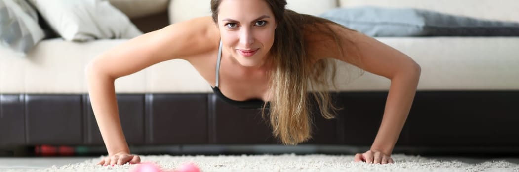 Young beautiful sports girl doing exercises at home on couch. Healthy lifestyle. and woman doing sports at home doing plank
