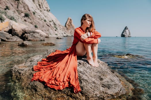 Woman travel sea. Happy tourist taking picture outdoors for memories. Woman traveler looks at the edge of the cliff on the sea bay of mountains, sharing travel adventure journey.