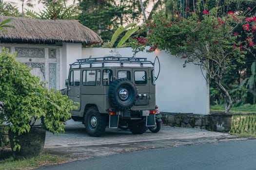 Back view of safari jeep parked at home garden. Travelling adventure car at parking house place