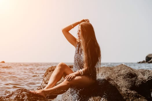 Woman travel sea. Young Happy woman in a long red dress posing on a beach near the sea on background of volcanic rocks, like in Iceland, sharing travel adventure journey