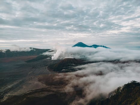 Landscape view of misty mount Bromo volcano. Foggy morning in the java national park with mount Semeru