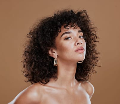 Black woman, beauty and skincare face portrait for natural afro, facial or hair care cosmetics. Healthy, beautiful and assertive model with curly hair shine and texture in brown studio background