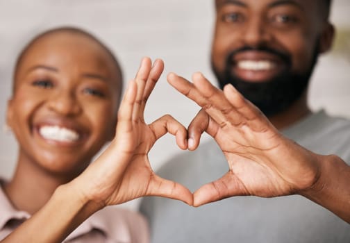 Love, hands in heart and black couple with smile for relationship, dating and commitment in home. Happy, emoji and face of black woman and man smile with hand shape for bonding, romance and trust.