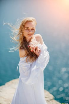 Portrait of a blond woman at the sea, a woman makes photos for memory from a trip to the sea to show to friends