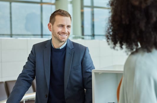 Happy, conversation and businessman and woman in an office talking, coworking and together. Smile, business and corporate employees speaking, in communication and discussion in the morning at work.