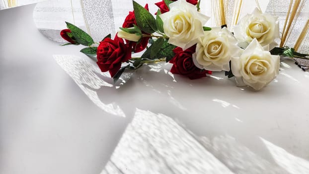 Background and texture with beautiful white and red roses with light and shadow from sun. Abstract cart with frame framed with roses, copy space and place for text. Concept of gifts, beauty, holiday