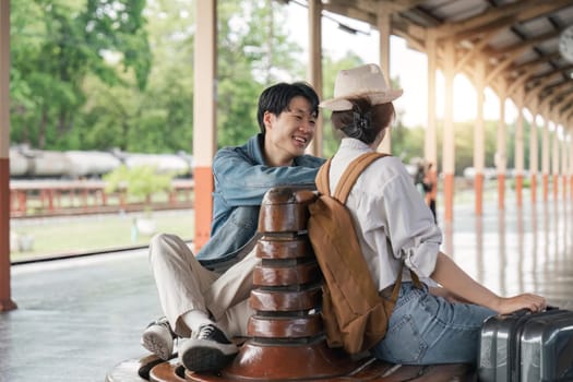 Asian couple chatting while waiting for upcoming train.