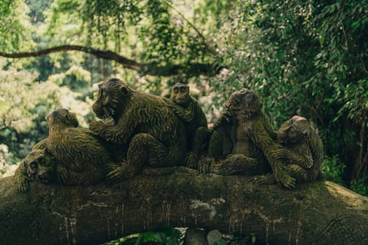 Stone monkeys statues in sacred monkey forest. Old decorative monkey sculptures in ubud sacred forest