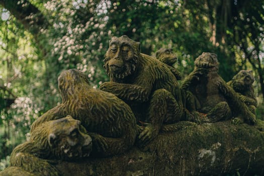 Stone monkeys statues in sacred monkey forest. Old decorative monkey sculptures in ubud sacred forest